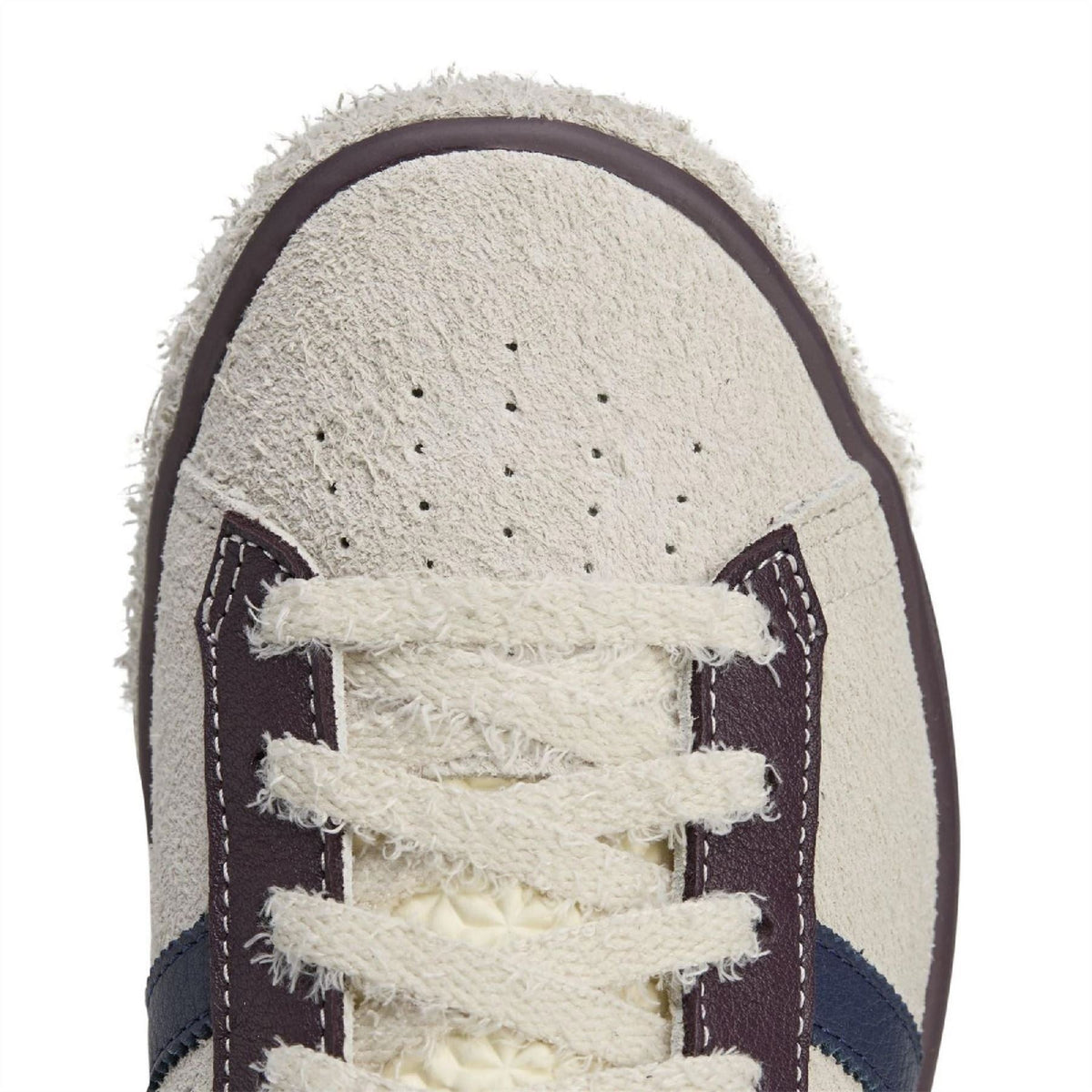 Cream suede sneaker toe with perforations, white laces and navy trim