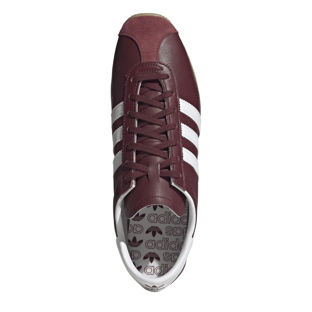 Burgundy lace-up sneaker with white stripes and Adidas logo on the tongue