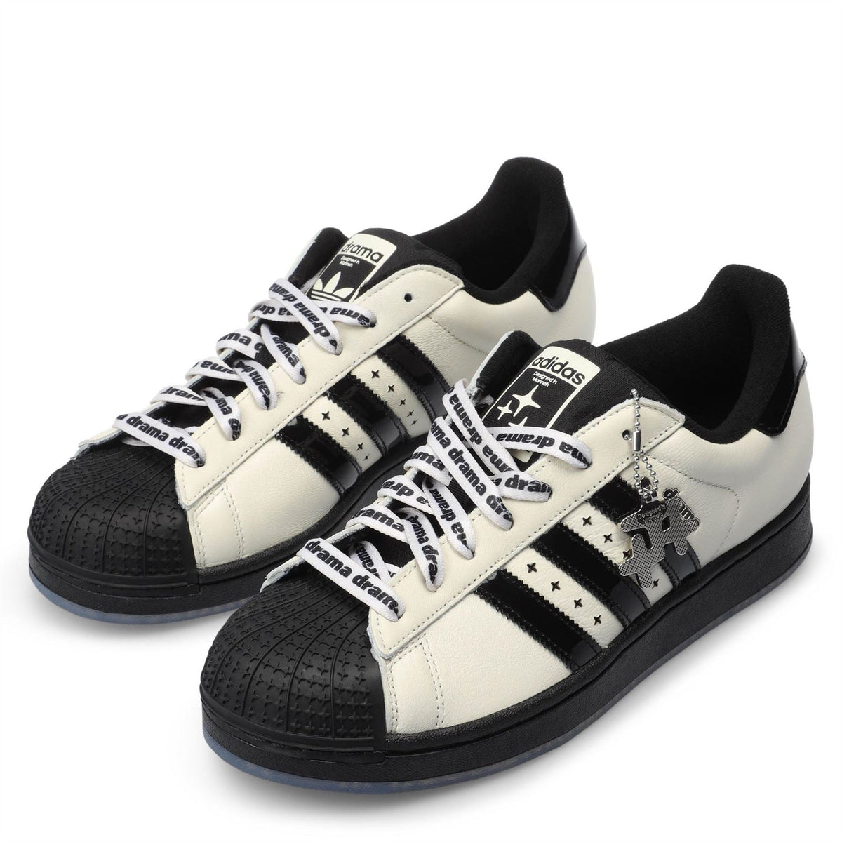 Pair of off-white and black lace-up trainers with embossed star and triple stripe panels