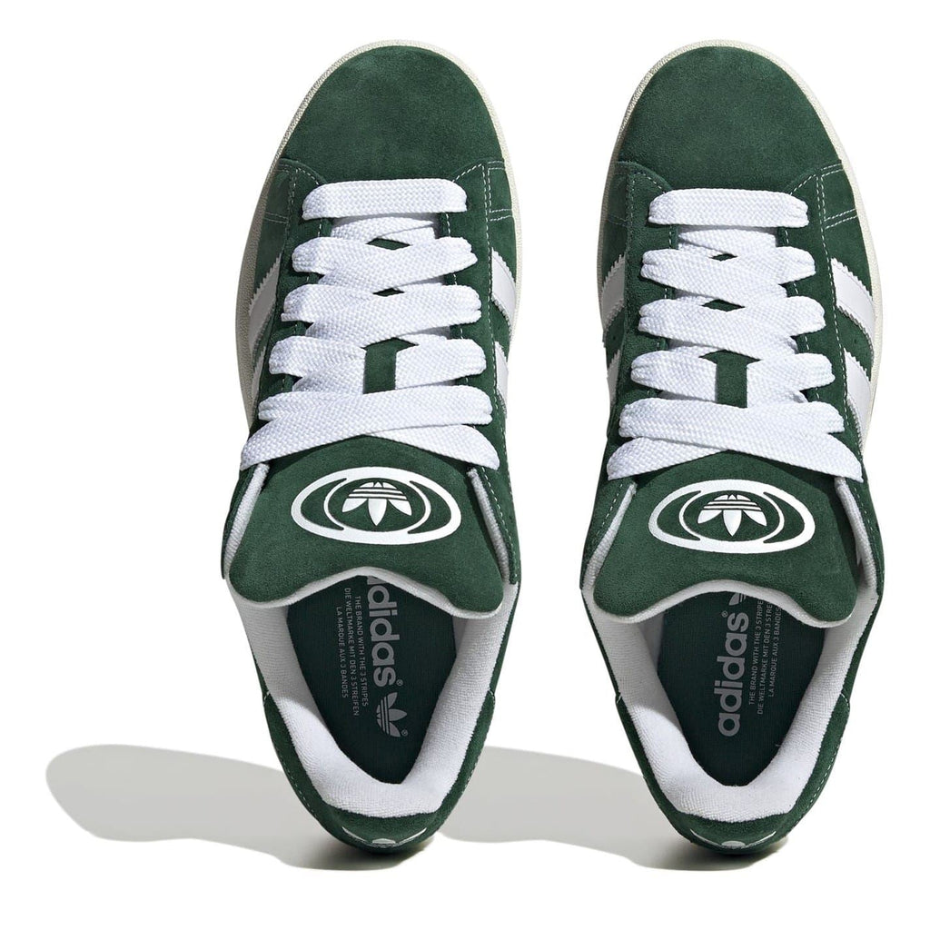 Pair of dark green low-top trainers showing adidas insole and white eyelets