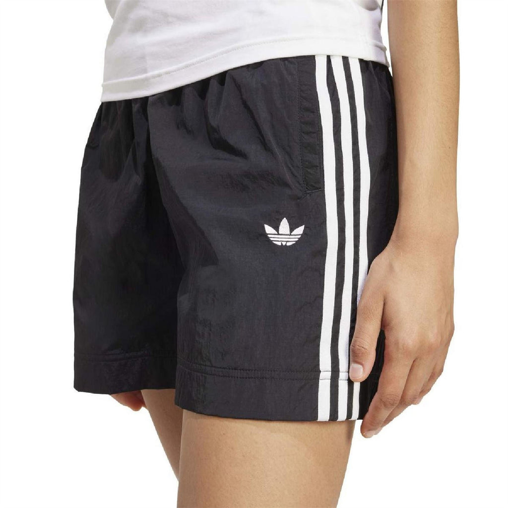 Black woven shorts with white vertical side stripes and small trefoil logo.