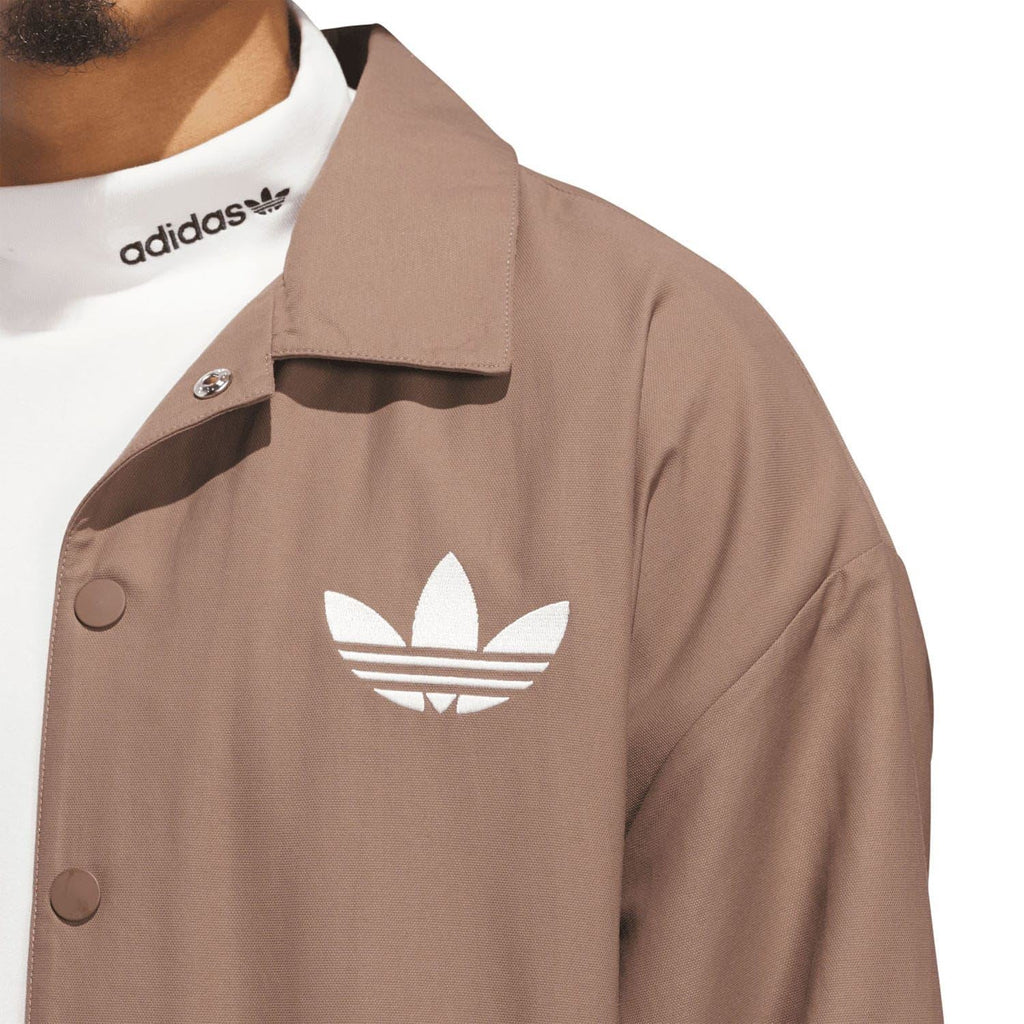 Brown coach overshirt close-up of trefoil logo and buttoned collar