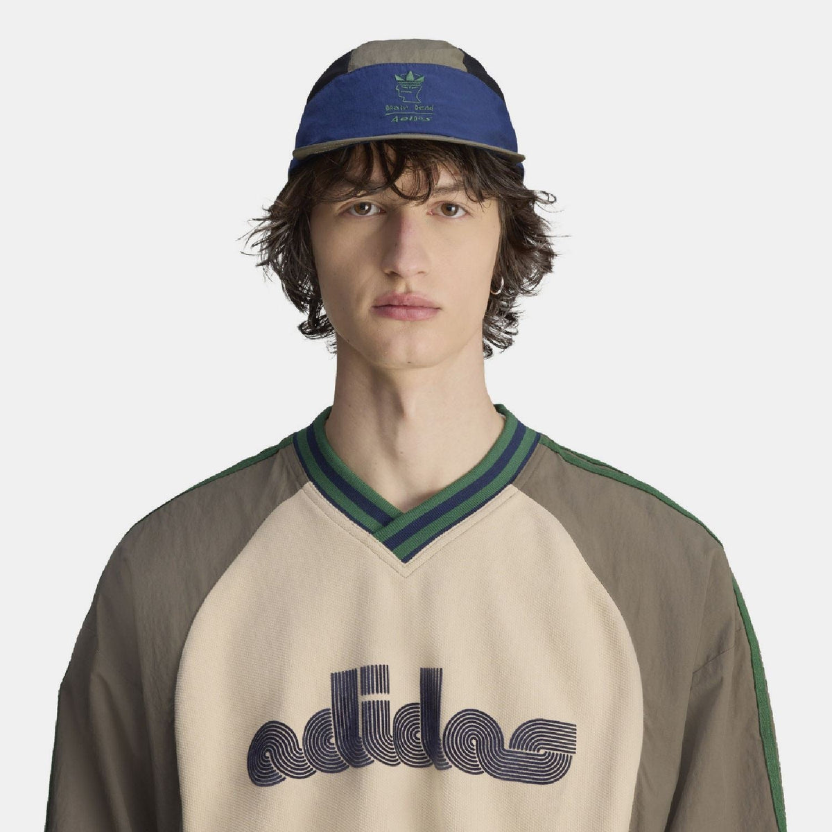 Two-tone cap worn by model, olive crown with blue band and dark mesh sides