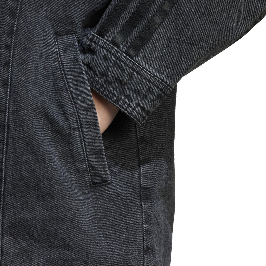 Black denim jacket sleeve detail with button cuff and vertical seam stitching