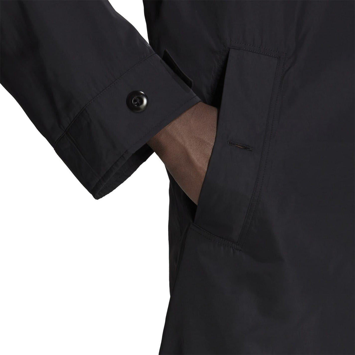 Black jacket sleeve and chest pocket close-up with button cuff detail.