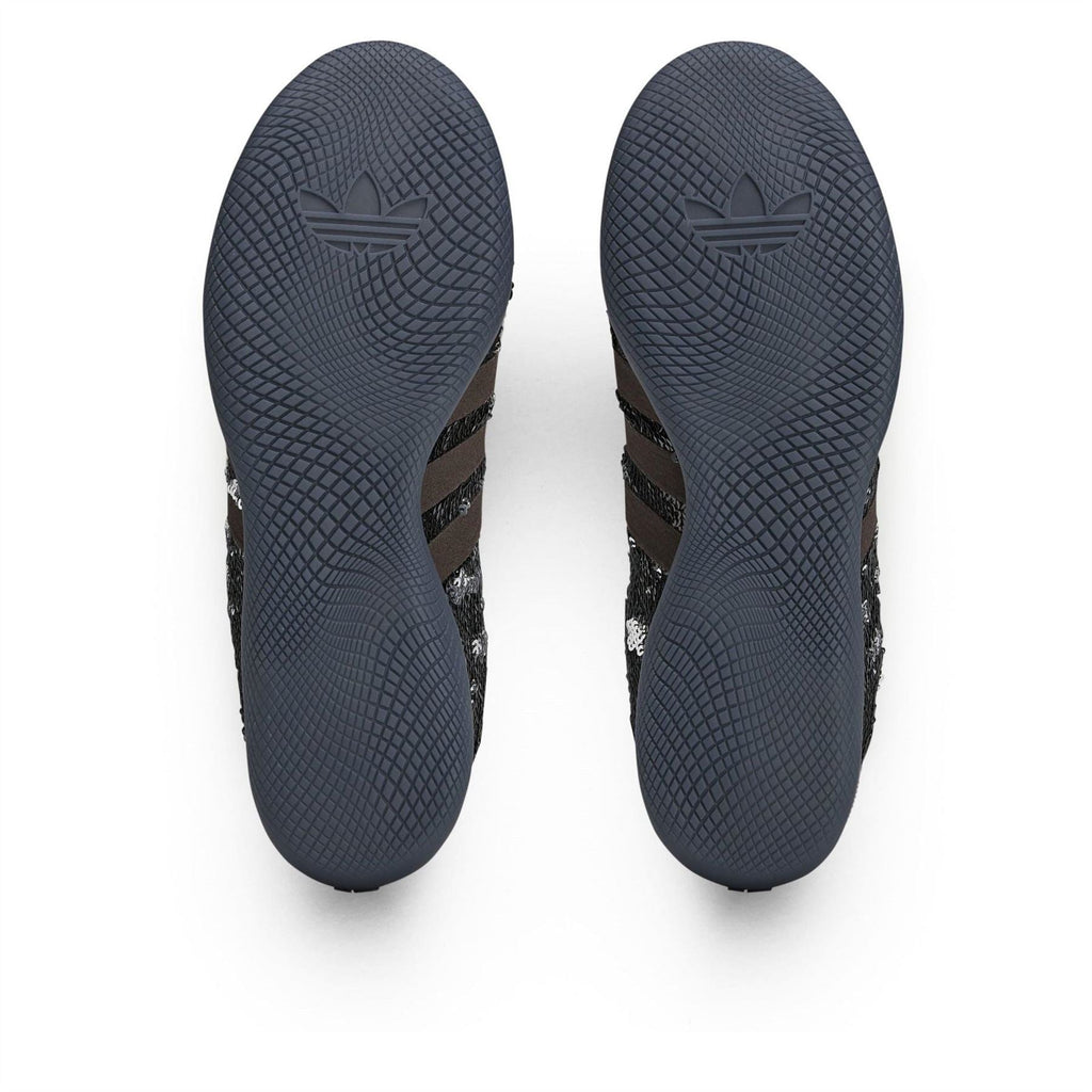 Outsole view of Core Black adidas sneakers with textured tread and adidas logo