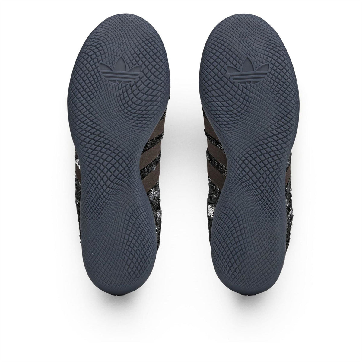 Outsole view of Core Black adidas sneakers with textured tread and adidas logo