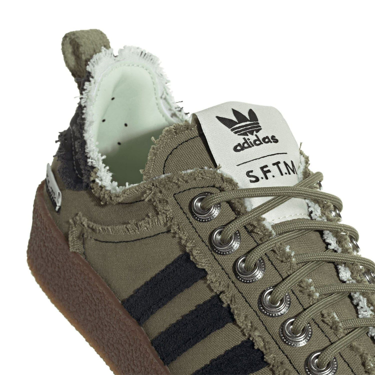 adidas Originals olive trainers close-up with adidas logo and S.F.T.M label