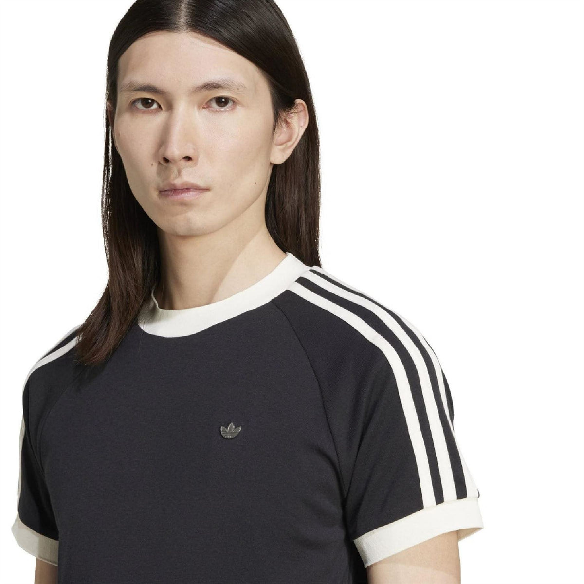 Black adidas Originals T-shirt close-up with trefoil logo and white three-stripe sleeves