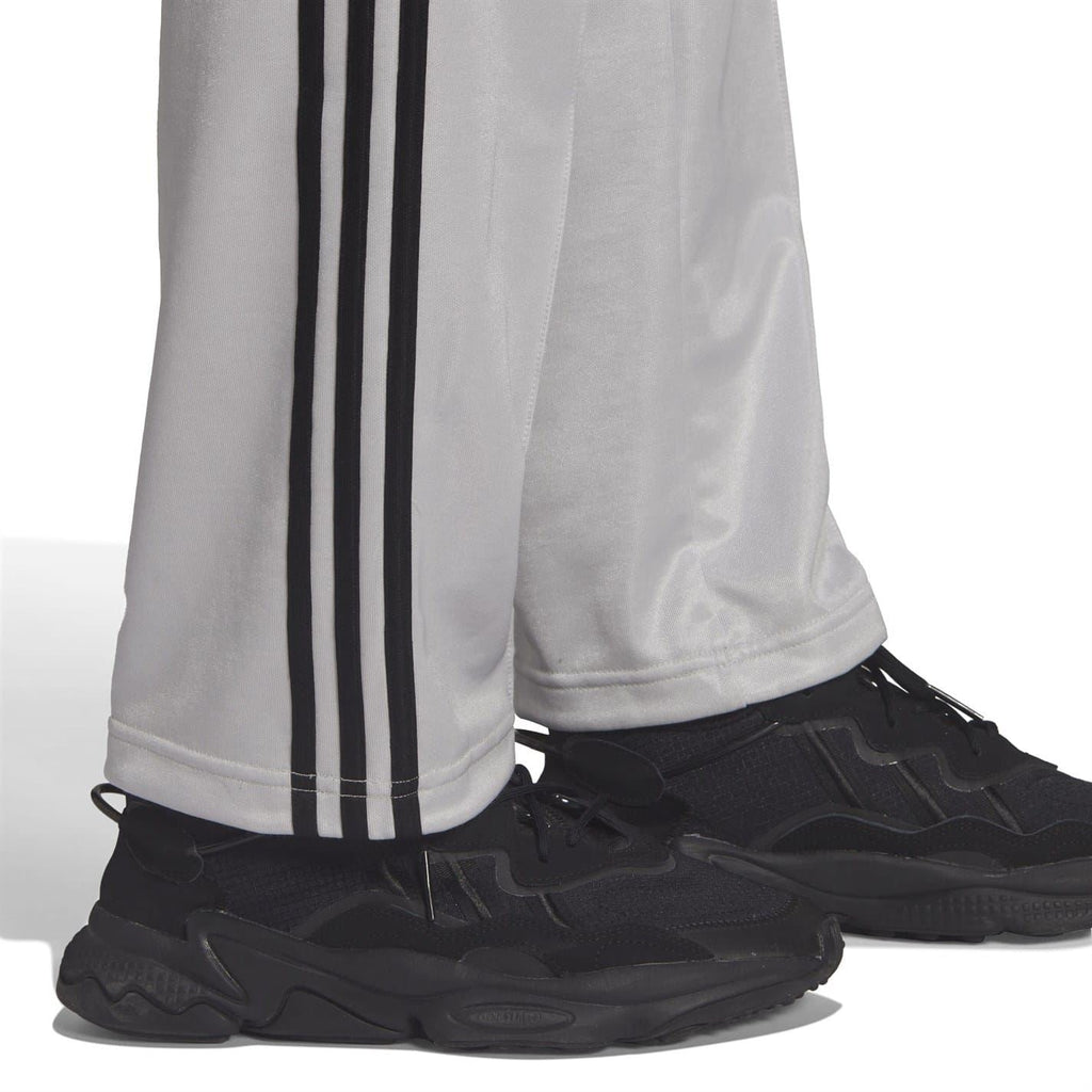 Light gray sweatpants with black side stripes and elastic cuffs over sneakers