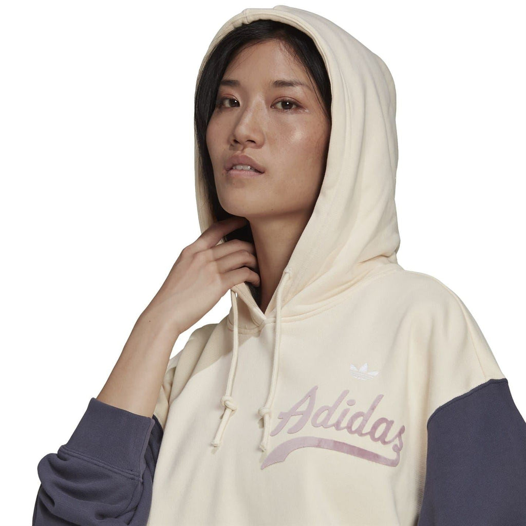 Close-up cropped hoodie hood with drawstrings, cream fabric with Adidas logo on chest