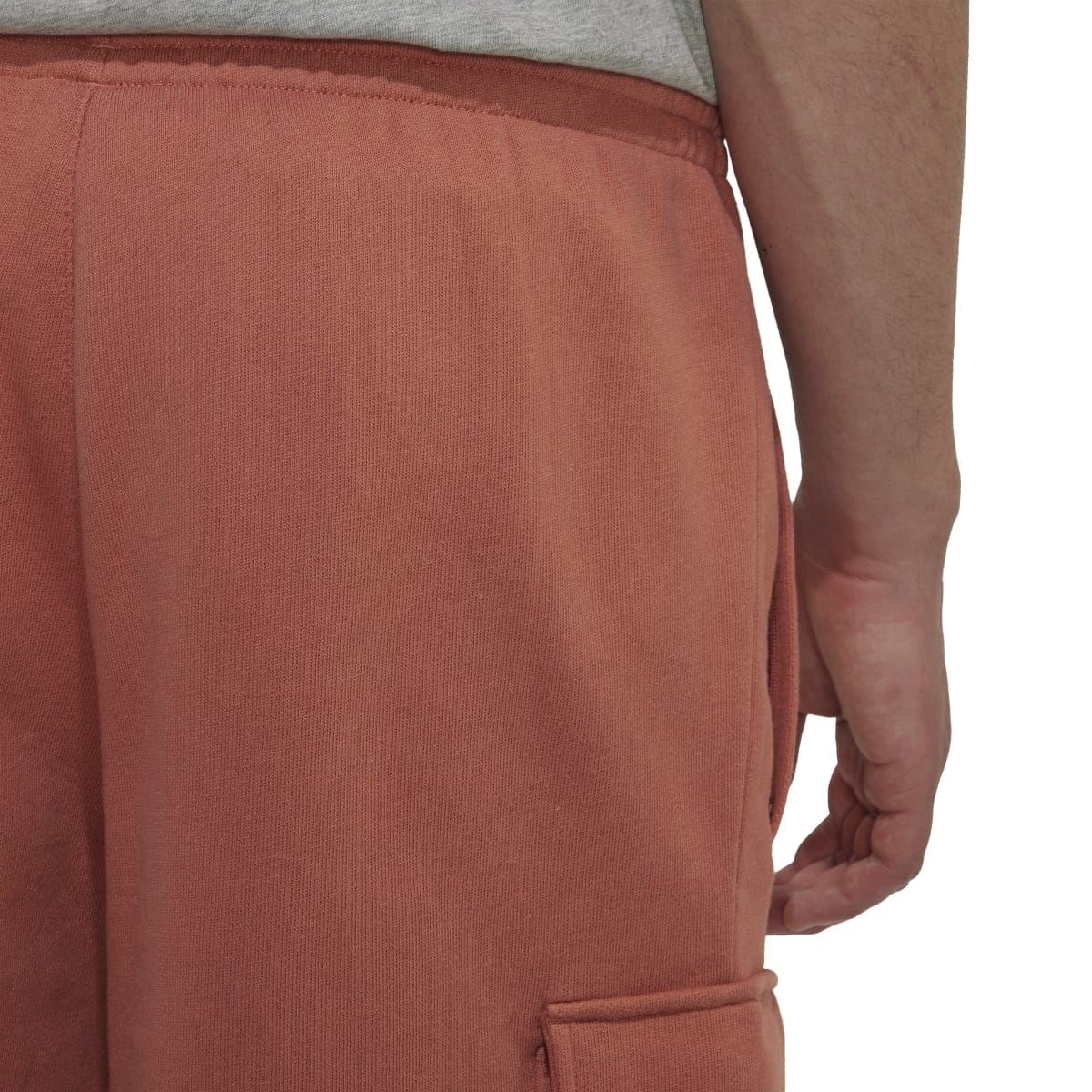 Rust-brown cargo shorts close-up of front pocket and fabric texture