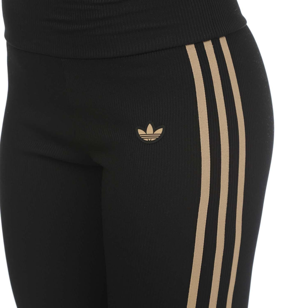 Black leggings with adidas trefoil logo and three gold vertical side stripes