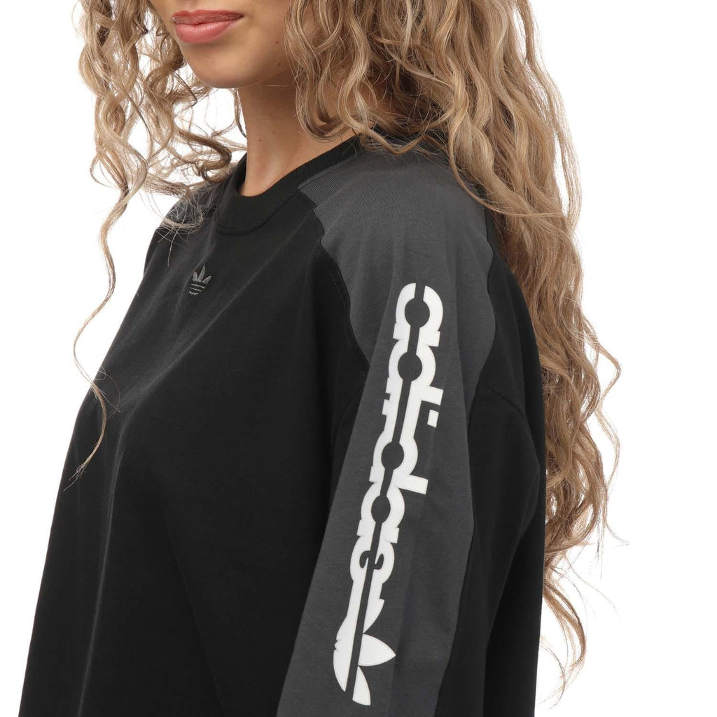 adidas Originals black crop T-shirt close-up, sleeve graphic print with chain and trefoil