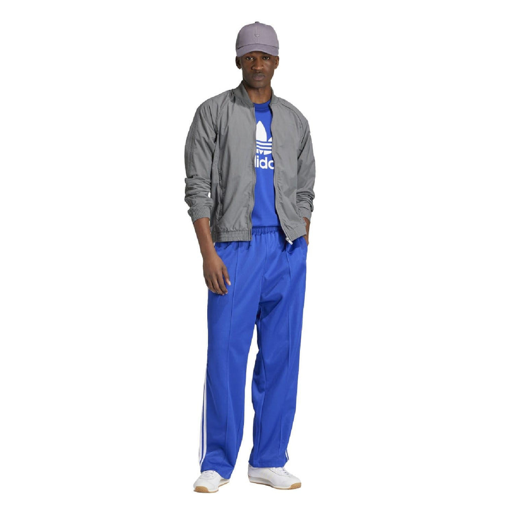Blue crew-neck t-shirt with white adidas trefoil logo, worn under gray jacket