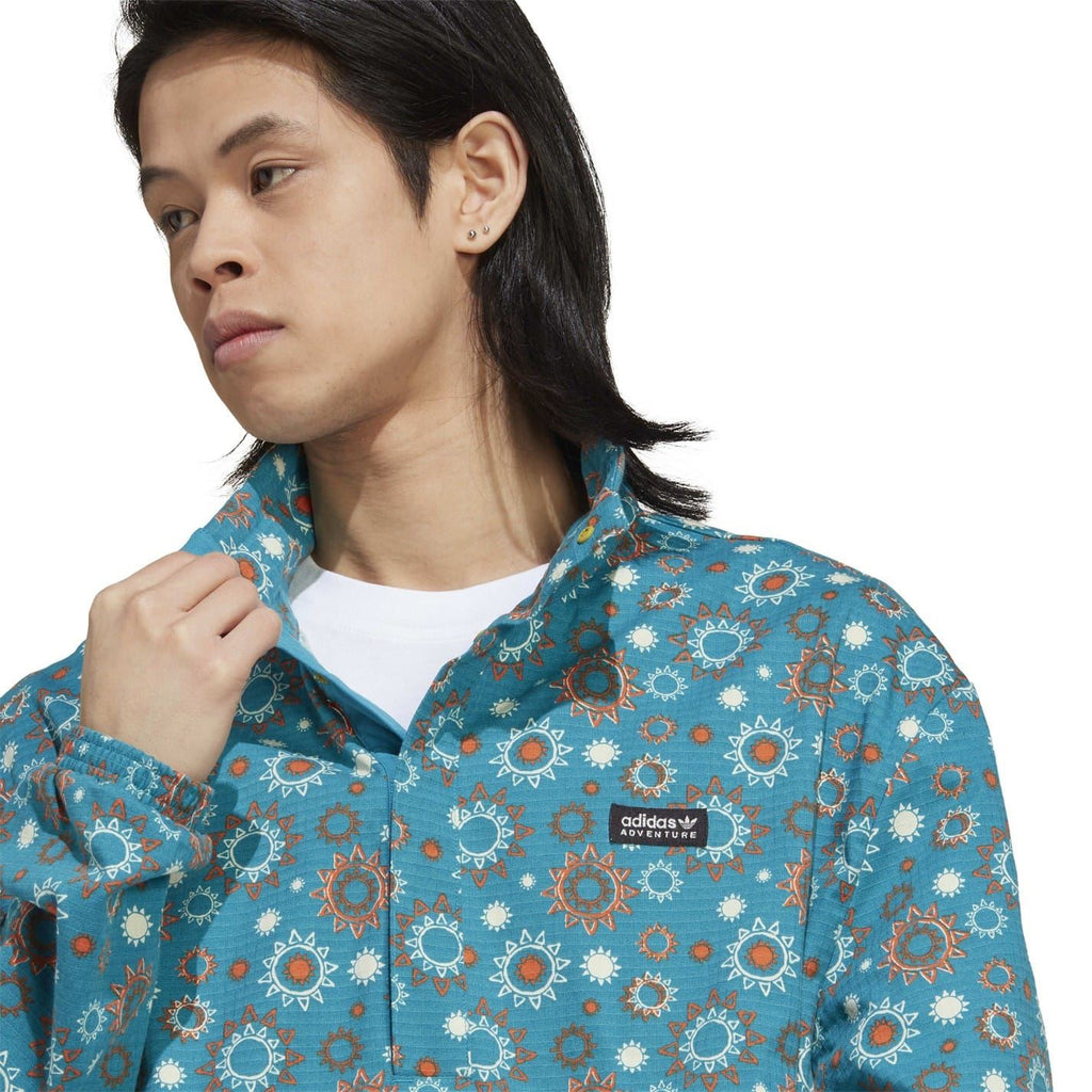 adidas hooded quarter-zip relaxed shirt close-up in teal floral print with logo label
