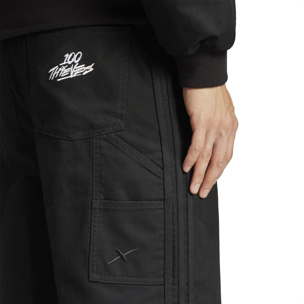 adidas Originals 100T black pants with “100 TREFOILS” graphic on leg pocket