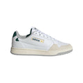 White adidas Originals trainers with green heel panel, gold logo, lace-up design