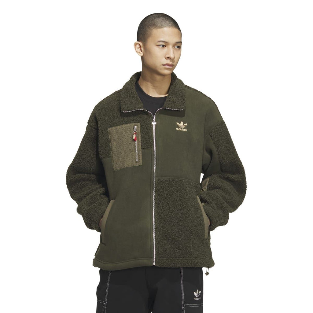 Olive green Sherpa full-zip jacket on model, stand collar, Adidas logo, fleece side panels