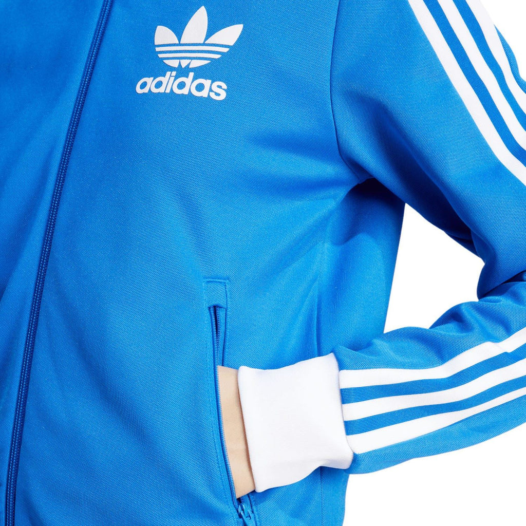 Blue jacket close-up: front zipper, white cuff, and three white sleeve stripe bands