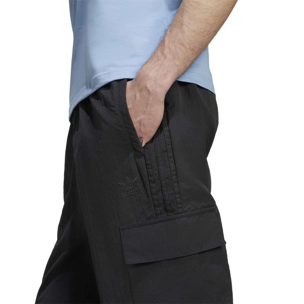 Adidas Originals black cargo pants close-up of flap pocket and woven texture