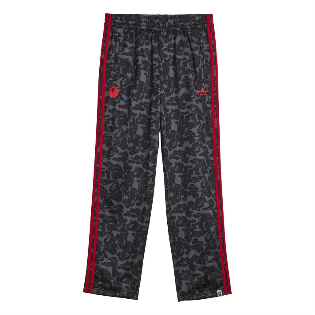 Black camo track pants with red side stripes and trefoil logo on thigh