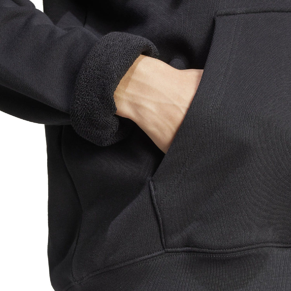Close-up of black hoodie sleeve cuff and kangaroo pocket seam detail
