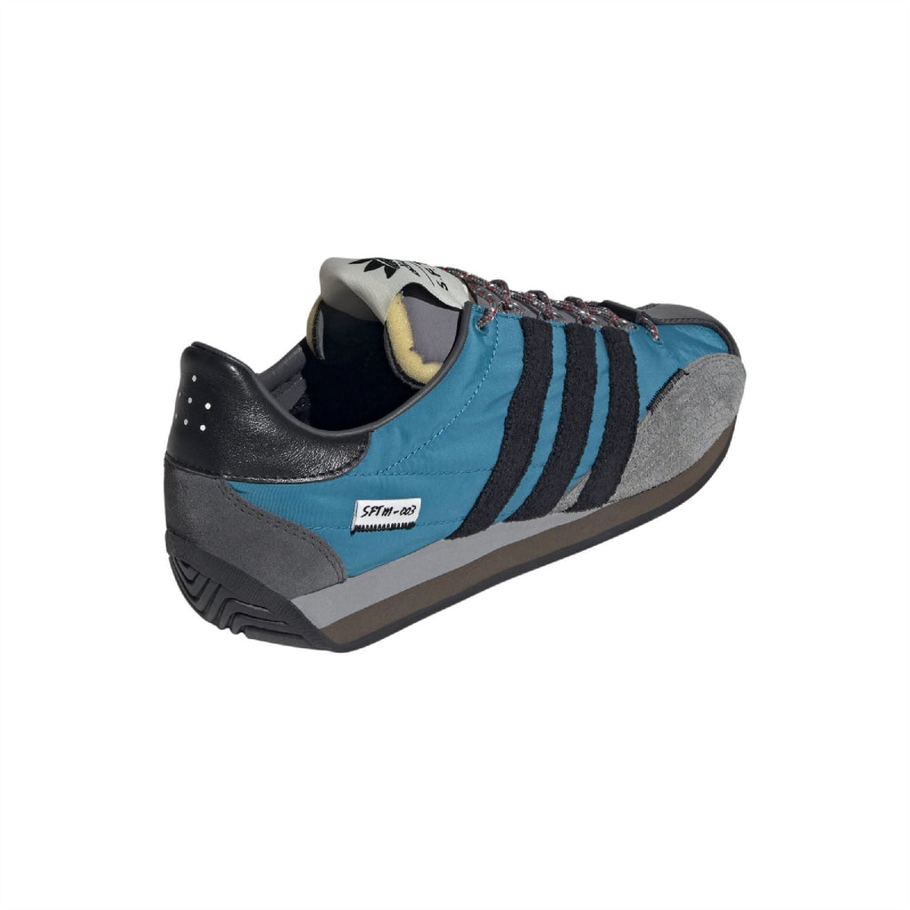 Side view teal trainers with black heel, gray suede toe and three blue stripe accents
