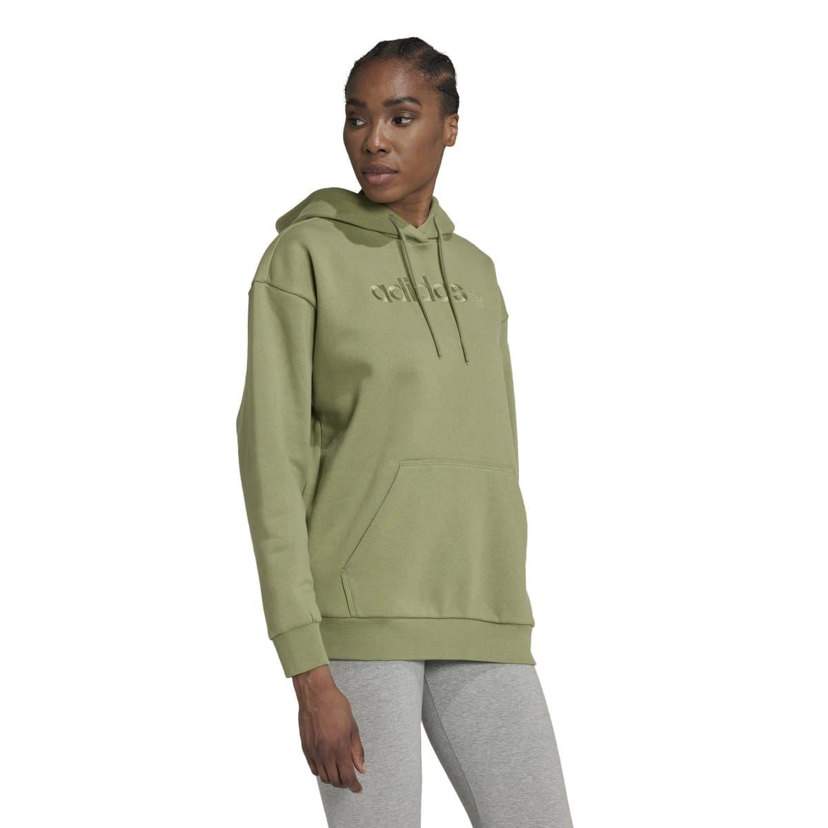Green adidas Originals pullover hoody on model, side view with front logo and hood