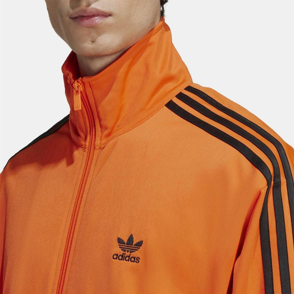 Orange track top with adidas logo on chest and zip-up stand collar