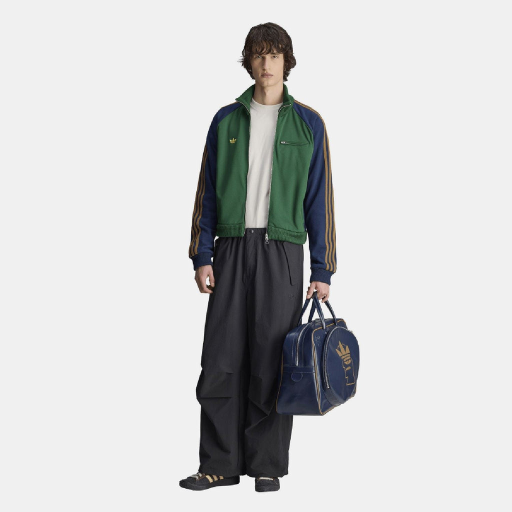 Navy duffel bag on model, front gold logo graphic and zipper pockets with top handles.