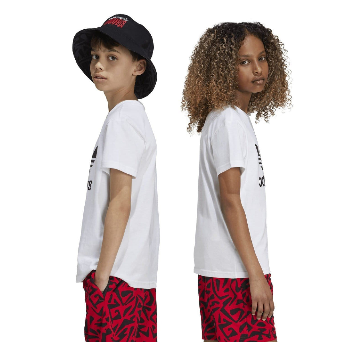 White junior adidas Trefoil t-shirt with chest logo, side view with red patterned shorts