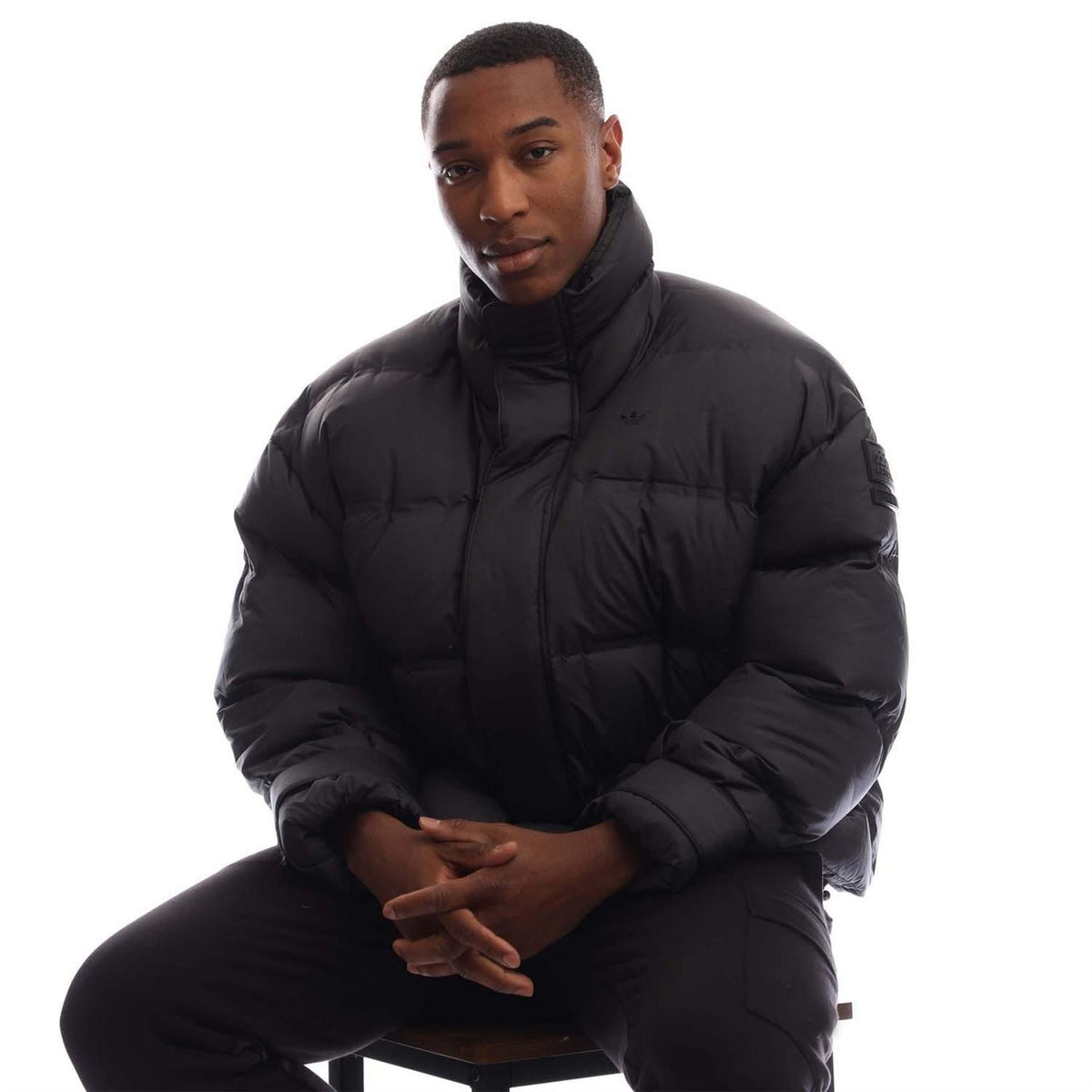 Black adidas Originals puffer jacket front view with quilted insulated design