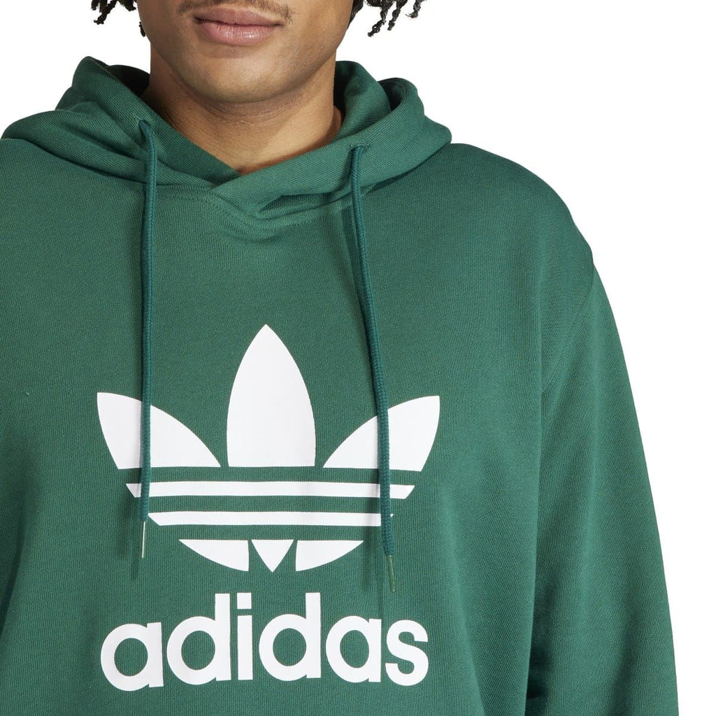 Green hoodie close-up of trefoil adidas logo and drawstring hood
