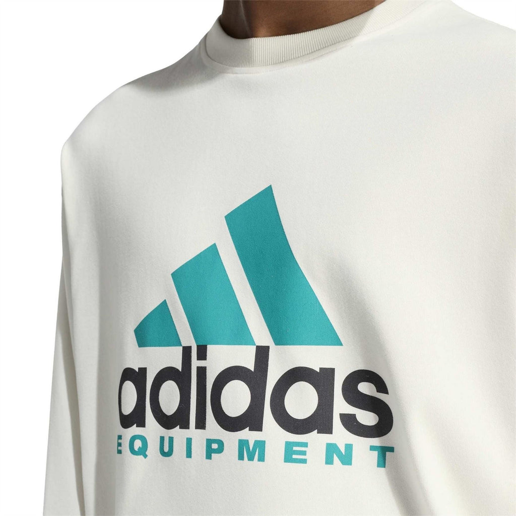 Off-white long-sleeve top close-up: teal adidas Equipment chest logo