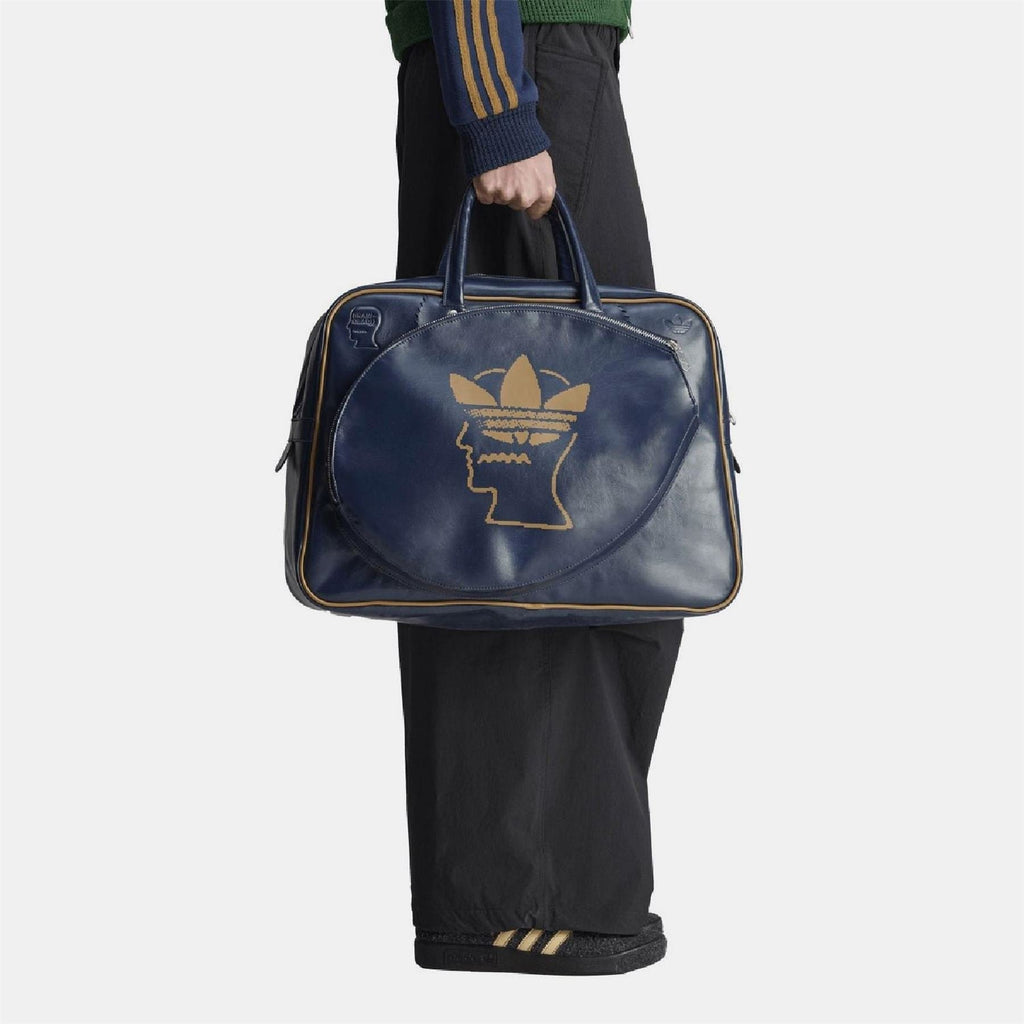 Navy duffel bag with top handles and front gold Trefoil head logo