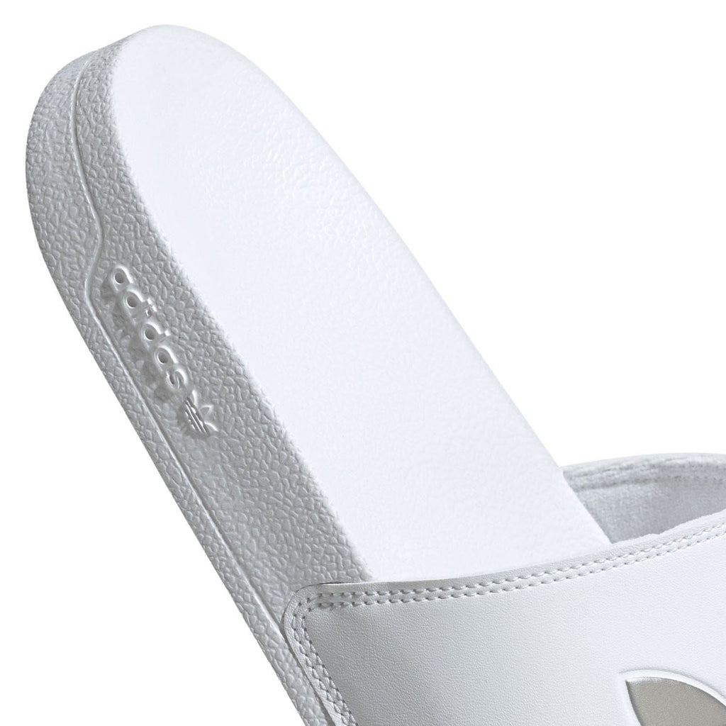 White adidas slide sandal heel and side view with embossed branding on sole