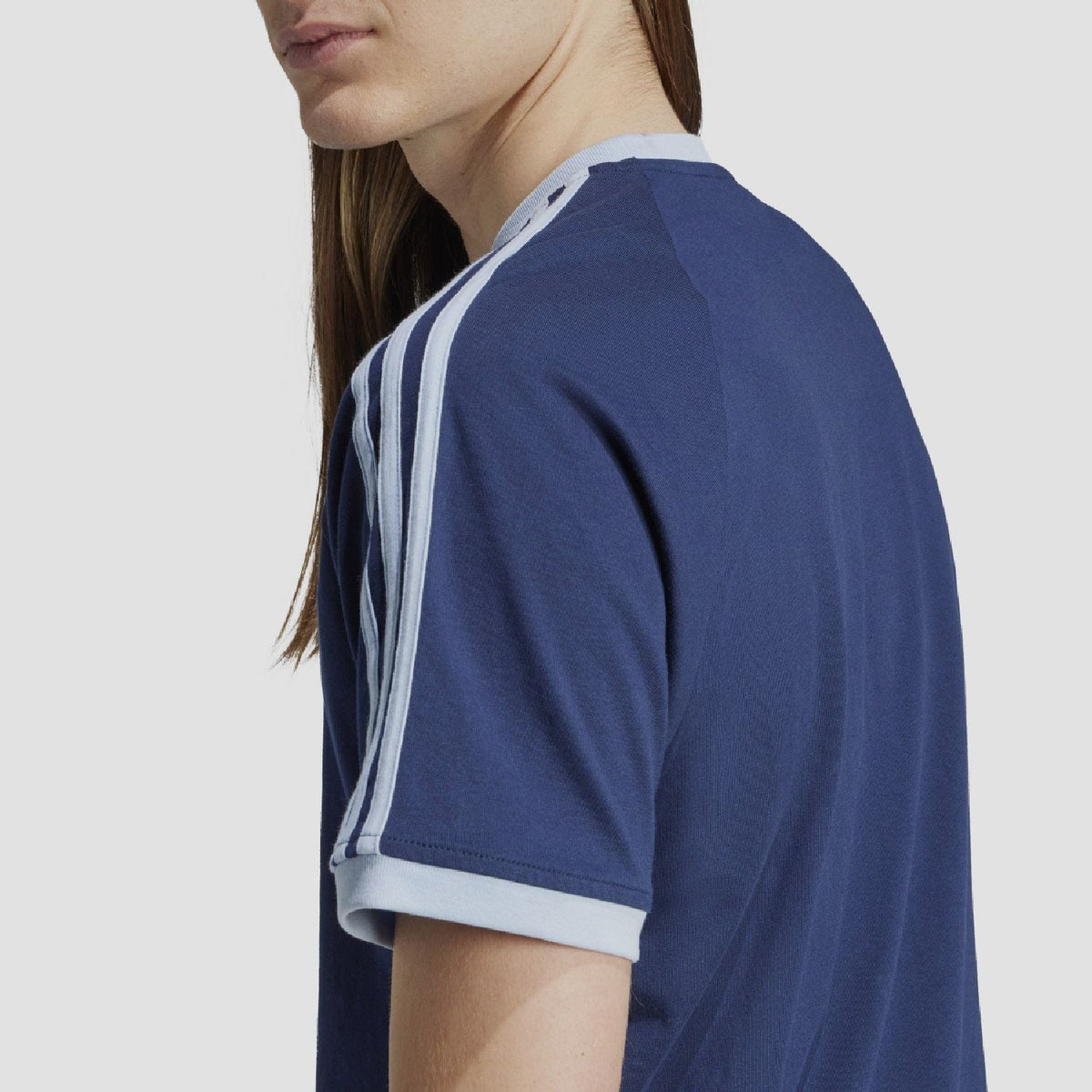 Indigo adidas Originals T-shirt close-up from side with white sleeve stripes