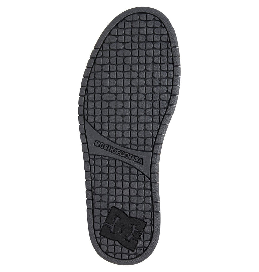 Black rubber shoe outsole with textured tread and DC logo mark near heel