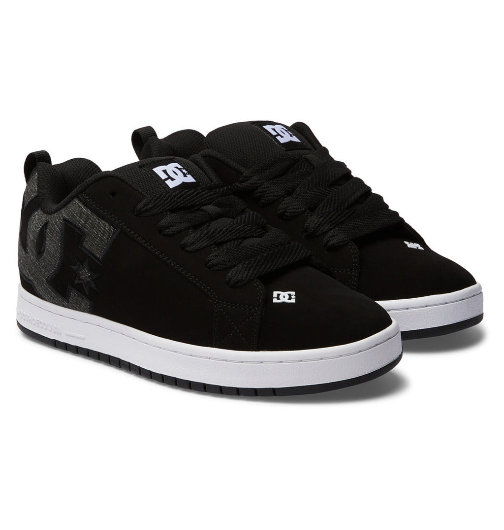 Black low-top sneakers with lace-up front, DC logos and star emblem details
