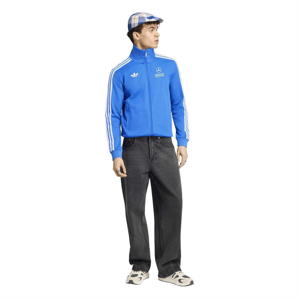 Blue track jacket with white adidas sleeve stripes, worn with dark jeans
