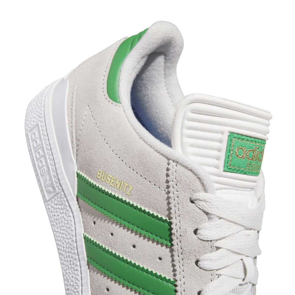 Close-up of white upper with green stripes, lace panel, and BUSENITZ label.