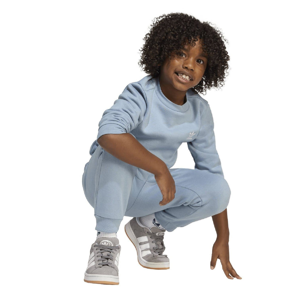 Light blue infant adidas Originals sweatshirt and joggers set, crouching pose.