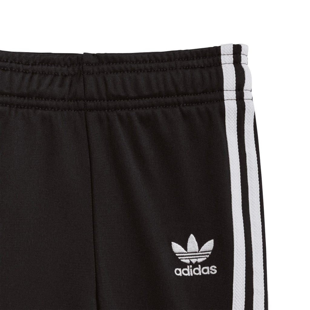 Infant black track pants with elastic waistband and white side stripe with adidas logo