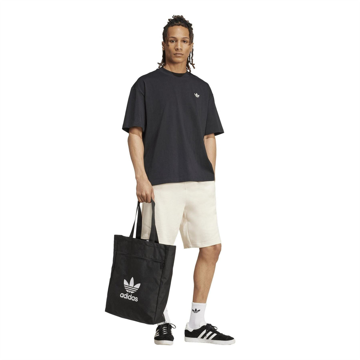 Cream Essentials shorts with black adidas T-shirt and bag, knee-length sporty style