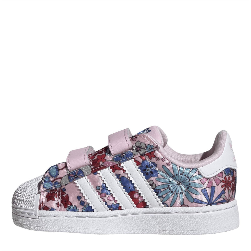 Pink and white low-top sneakers with two hook-and-loop straps and floral side stripes