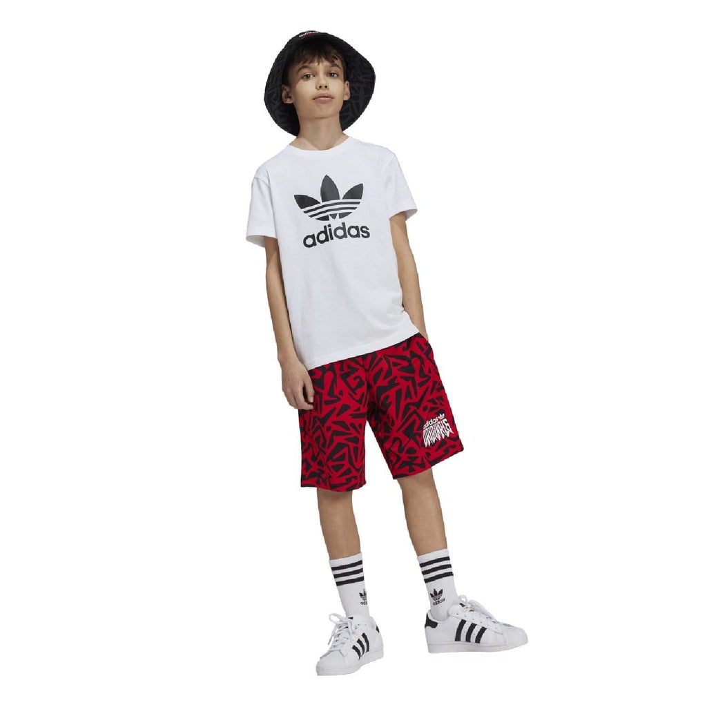 White junior adidas Trefoil t-shirt with chest logo, worn with red patterned shorts