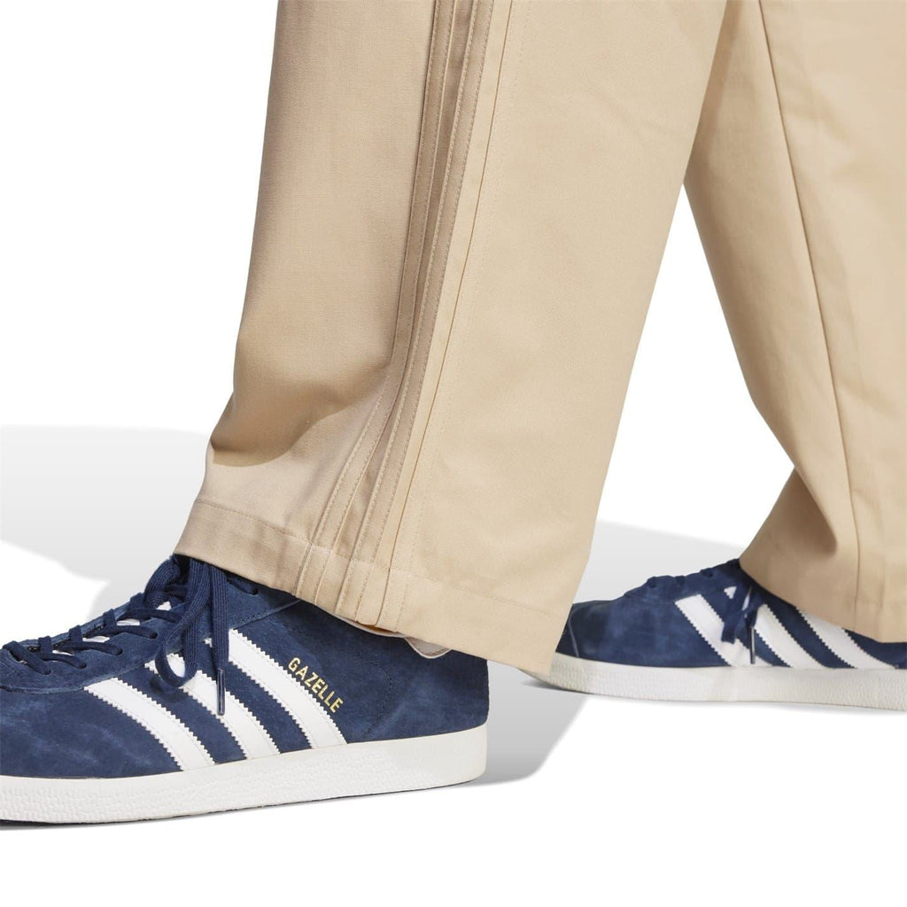 Beige trouser leg close-up with stitched side seam and clean hem