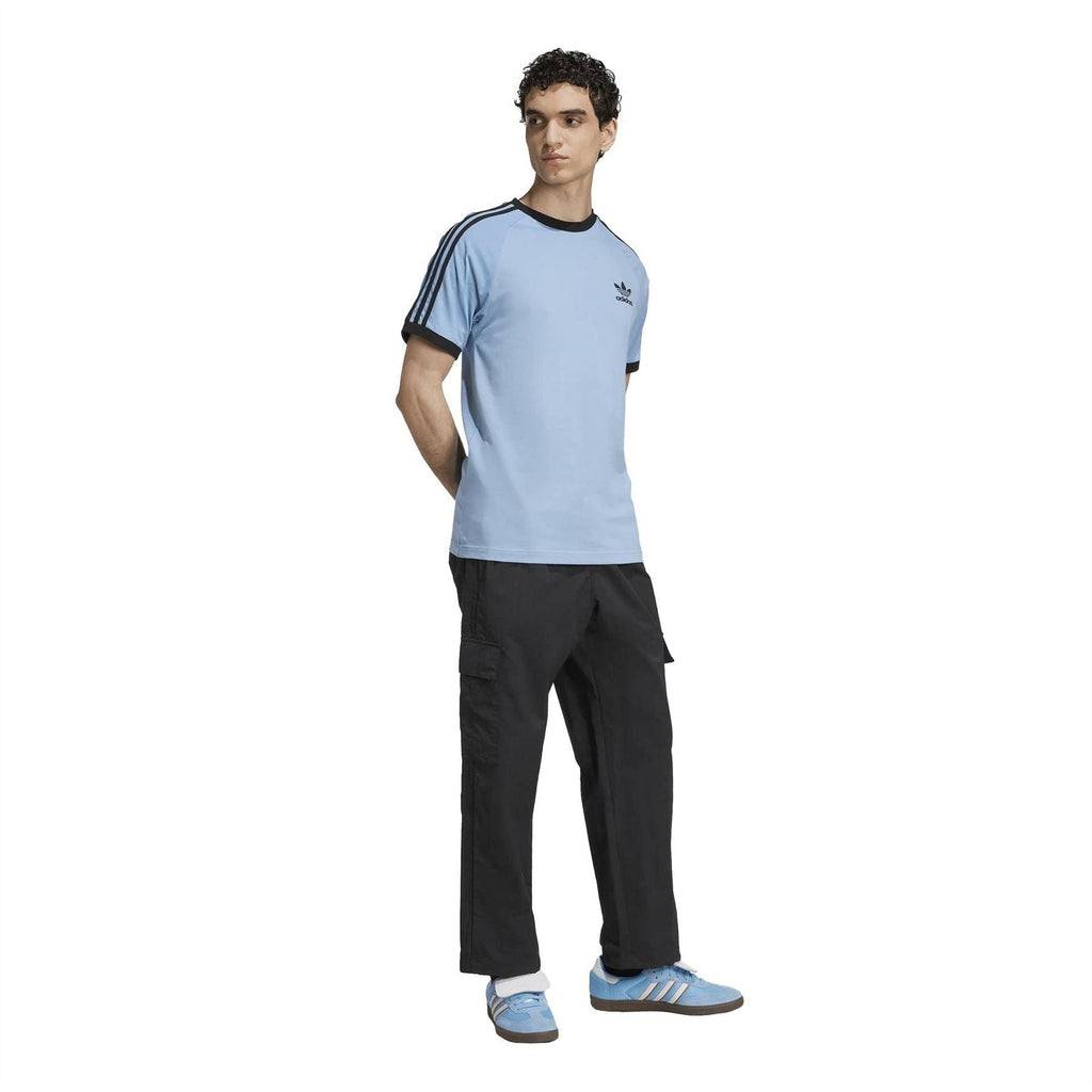 Adidas Originals black cargo pants on model, elastic waistband and flap pockets