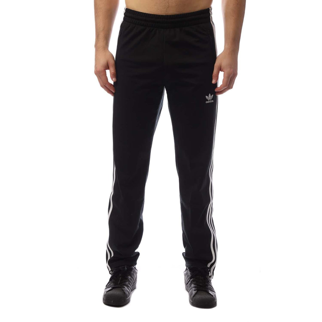 Black track pants with elastic waistband and side stripes, Adidas trefoil logo